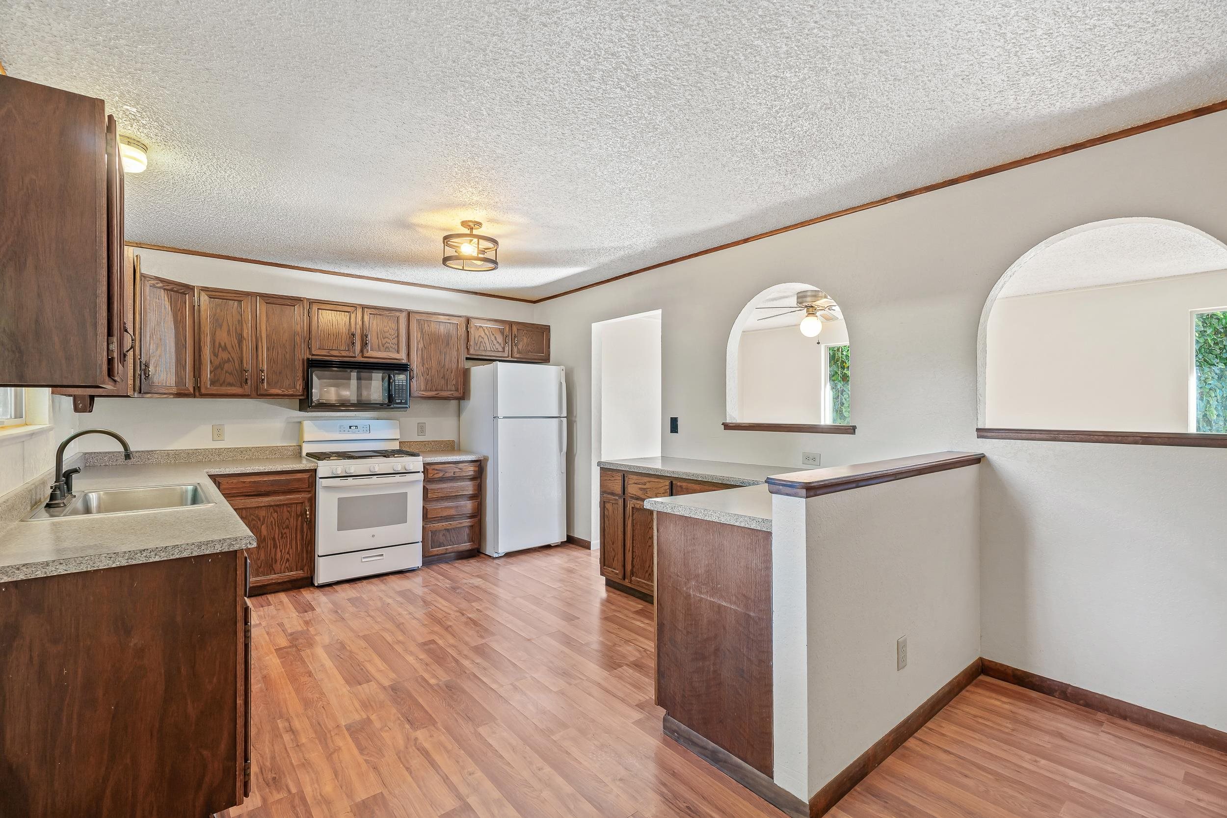 623 Broken Spoke Road Grand Junction, CO 81504 - Photo 6 of 27 a kitchen with stainless steel appliances granite countertop a sink cabinets and wooden floor