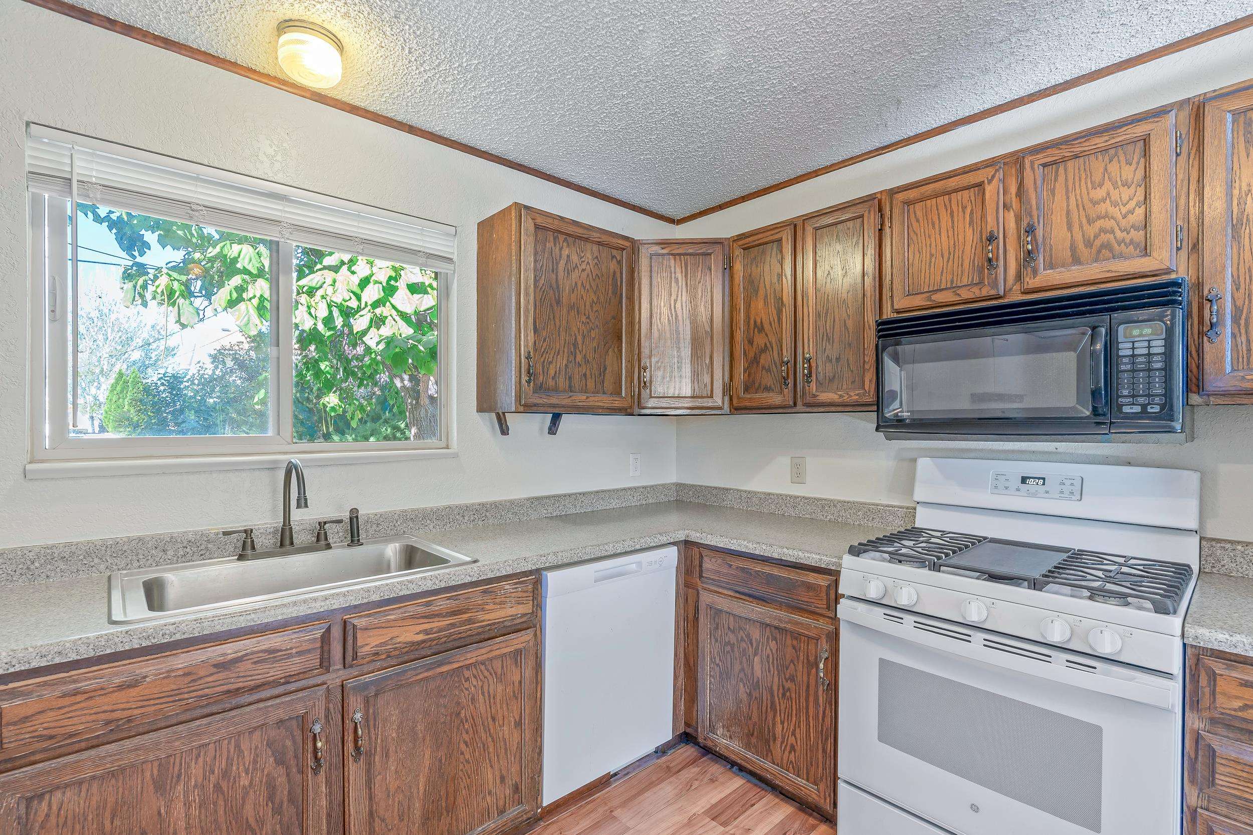 623 Broken Spoke Road Grand Junction, CO 81504 - Photo 7 of 27 a kitchen with stainless steel appliances granite countertop white cabinets a stove a sink and a microwave