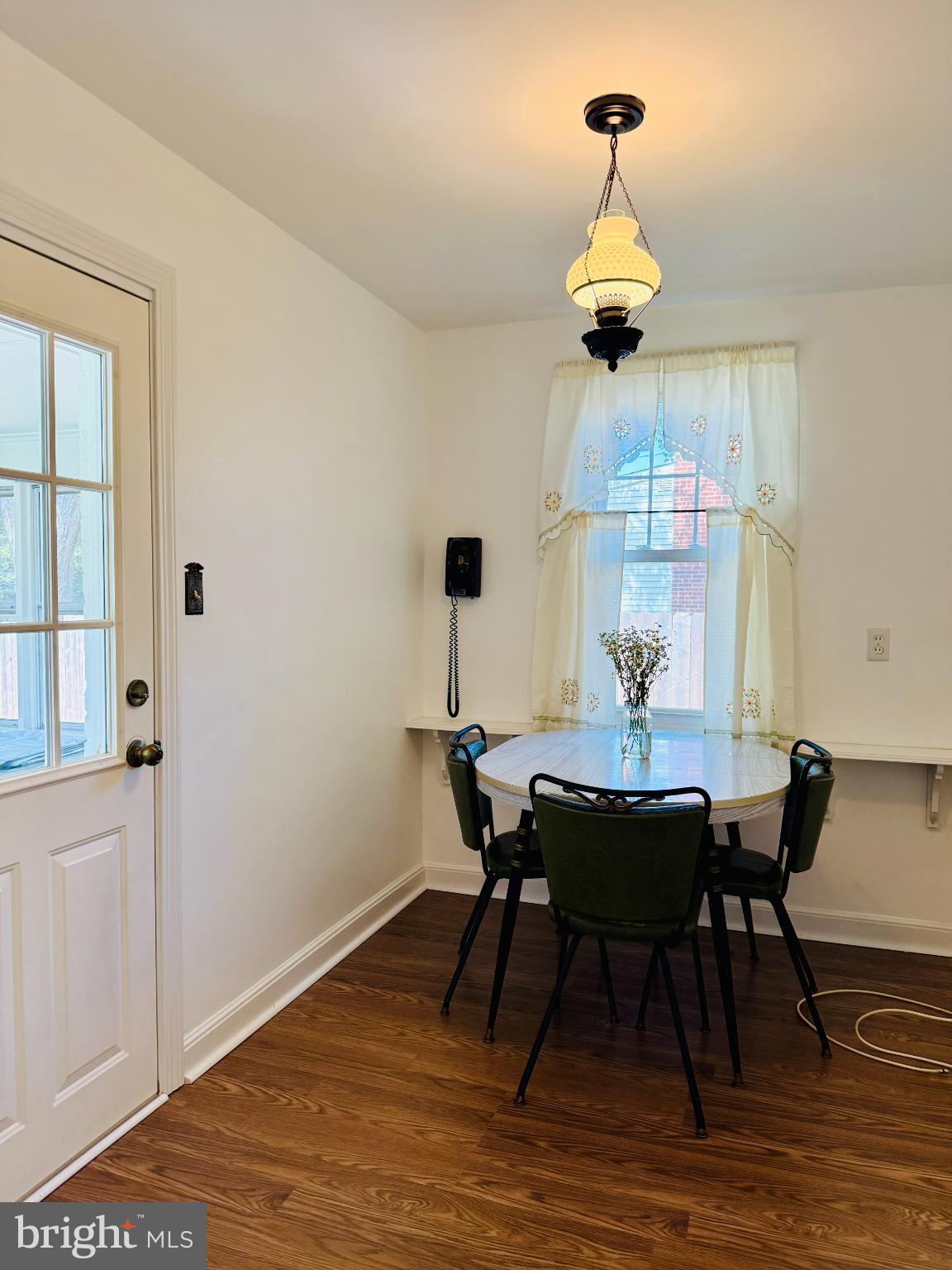 142 Rambling Way Springfield, PA 19064 - Photo 12 of 33 a dining room with wooden floor a chandelier a wooden table and chairs