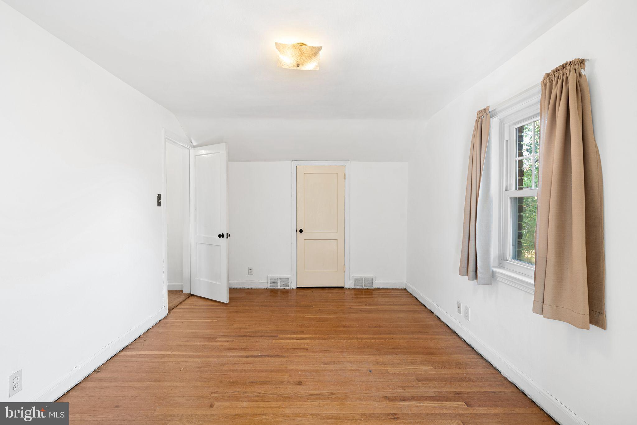 142 Rambling Way Springfield, PA 19064 - Photo 23 of 33 a view of an empty room with wooden floor and a window