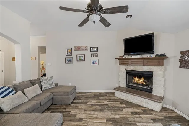 a living room with furniture a flat screen tv and a fireplace