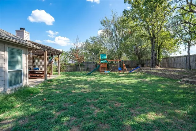 a view of a backyard with a garden and entertaining space