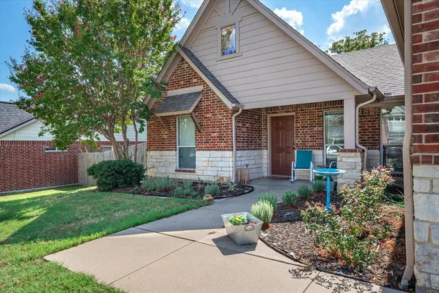 a front view of a house with a yard and potted plants