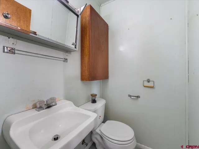 a bathroom with a sink a toilet and mirror