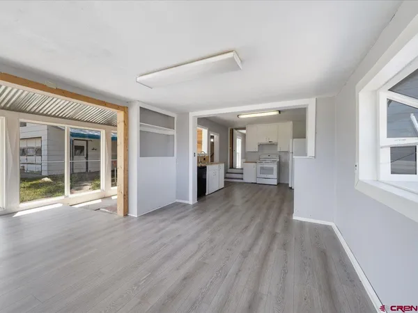 a view of a big room with wooden floor and windows