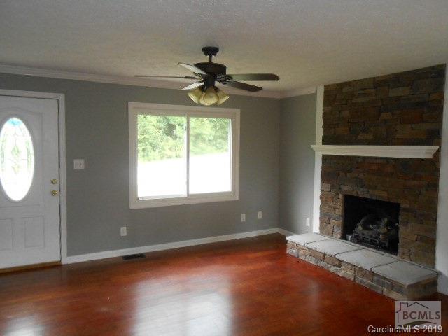 4808 Dentons Chapel Road Morganton, NC 28655 - Photo 11 of 20 a living room with wooden floor a fireplace and a chandelier