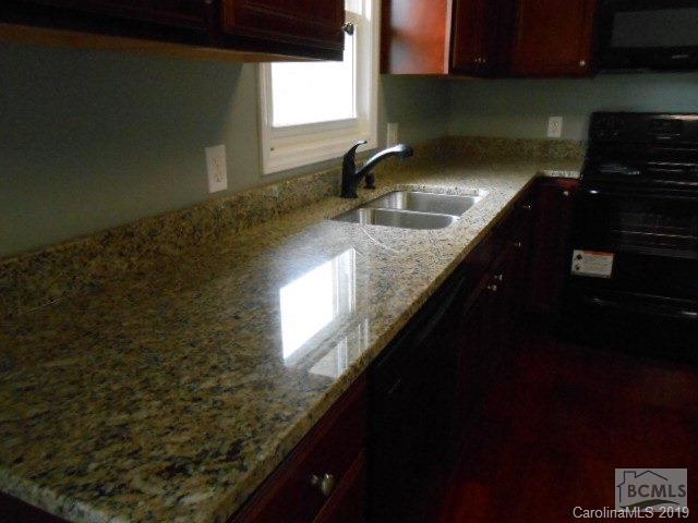 4808 Dentons Chapel Road Morganton, NC 28655 - Photo 17 of 20 a kitchen with granite countertop a sink stove and cabinets