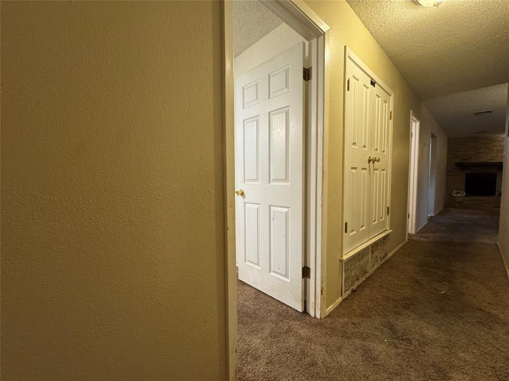 721 Mackey Ranch Road Bruceville-Eddy, TX 76524 - Photo 17 of 33 Textured walls, carpeted flooring, paneled doors, and a brick fireplace