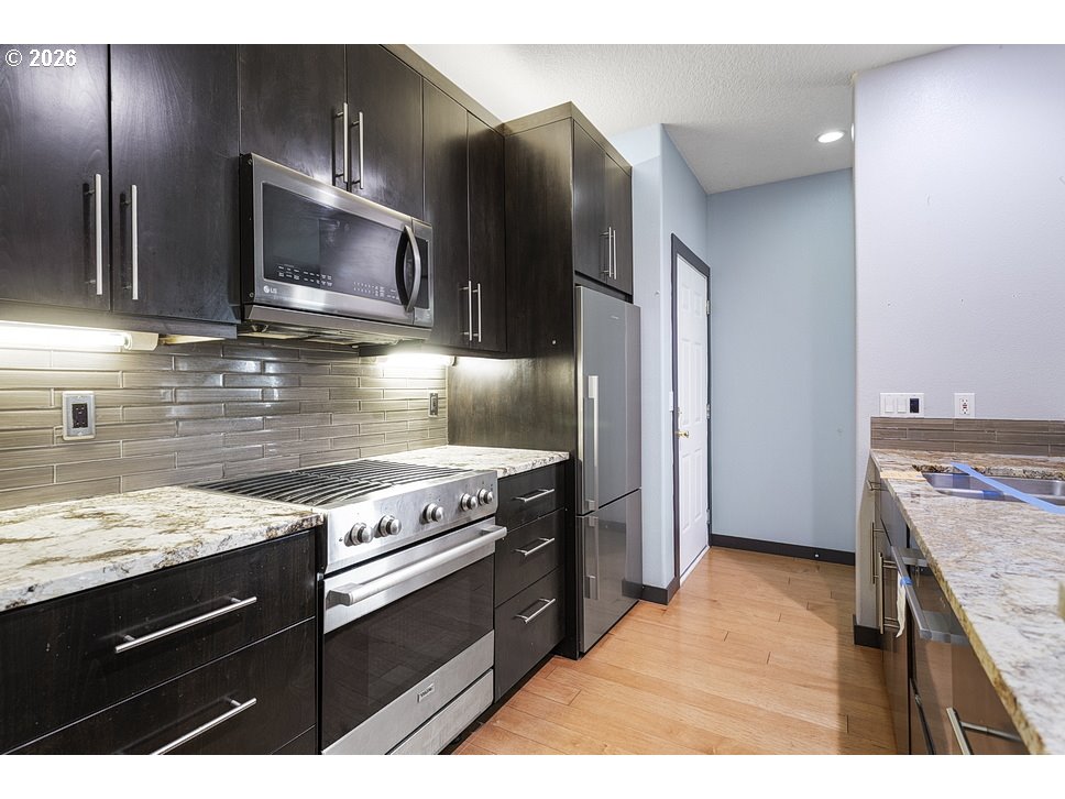 622 South Nevada Street, Unit D Portland, OR 97219 - Photo 11 of 37 a kitchen with a stove microwave and refrigerator