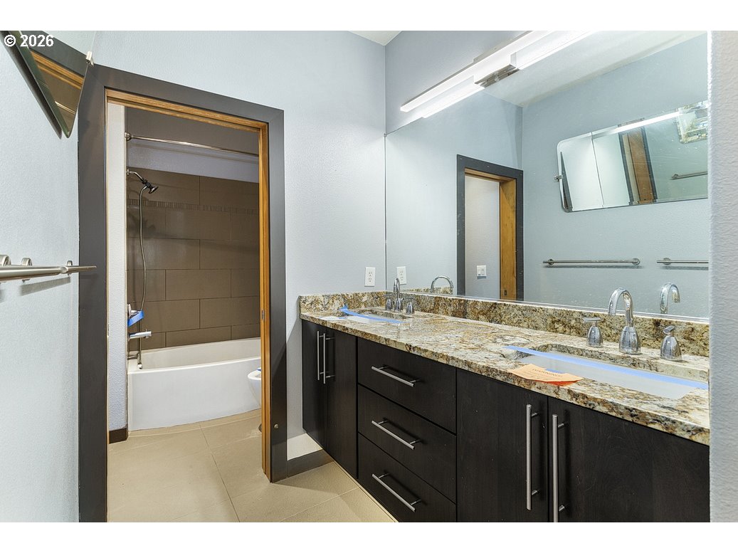 622 South Nevada Street, Unit D Portland, OR 97219 - Photo 24 of 37 a bathroom with a granite countertop sink tub and a mirror