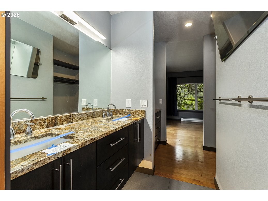 622 South Nevada Street, Unit D Portland, OR 97219 - Photo 25 of 37 a bathroom with a granite countertop sink and a mirror