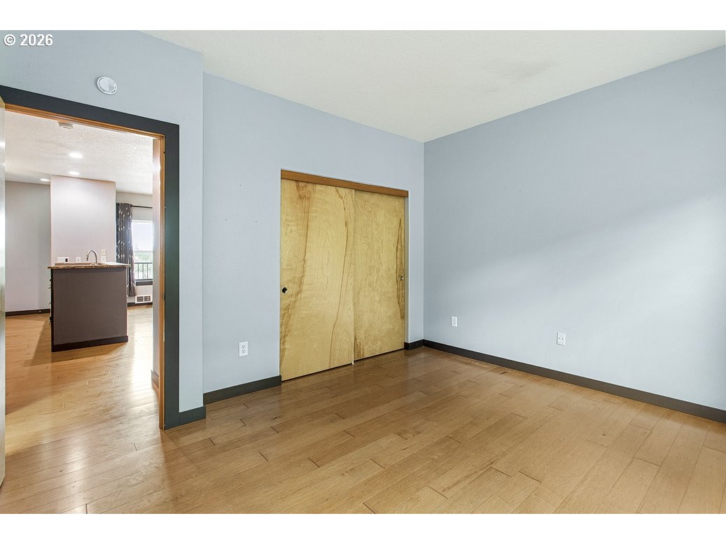 622 South Nevada Street, Unit D Portland, OR 97219 - Photo 31 of 37 a view of an empty room and a kitchen with wooden floor