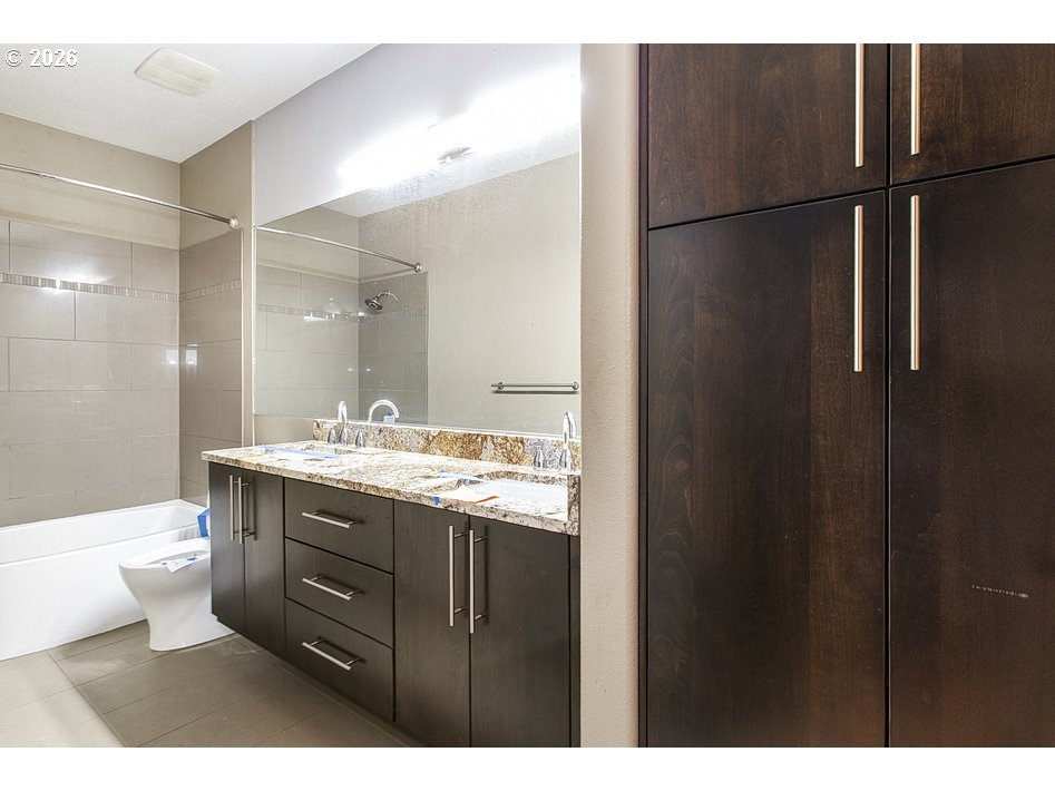 622 South Nevada Street, Unit D Portland, OR 97219 - Photo 33 of 37 a bathroom with a granite countertop sink toilet a mirror and shower
