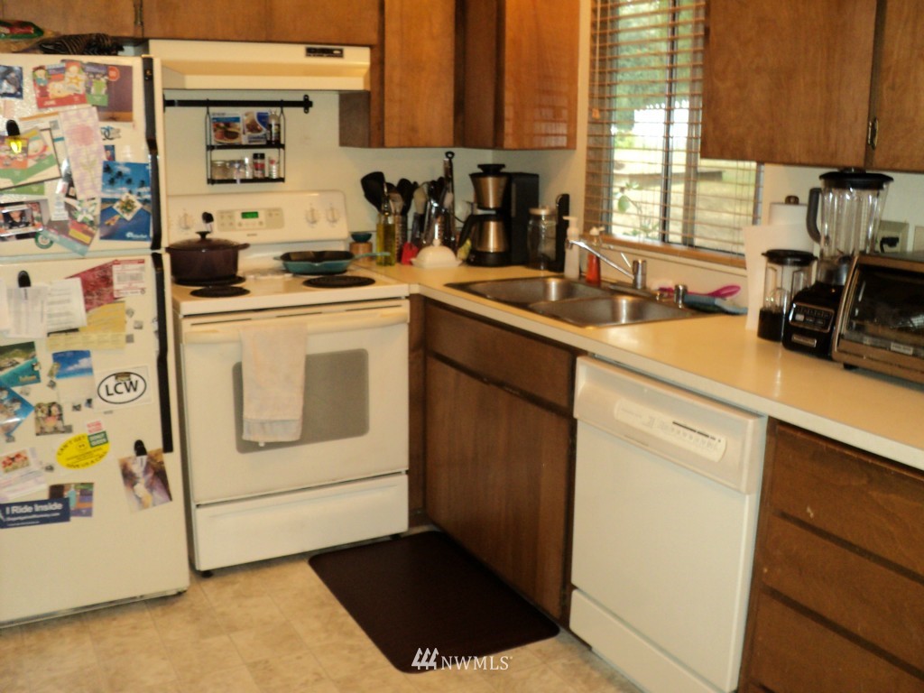 24302 Carter Road Bothell, WA 98021 - Photo 3 of 10 a kitchen with a sink stove and cabinets