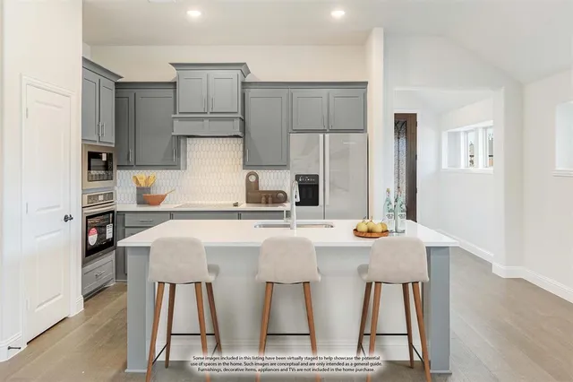a kitchen with stainless steel appliances a stove a table and chairs