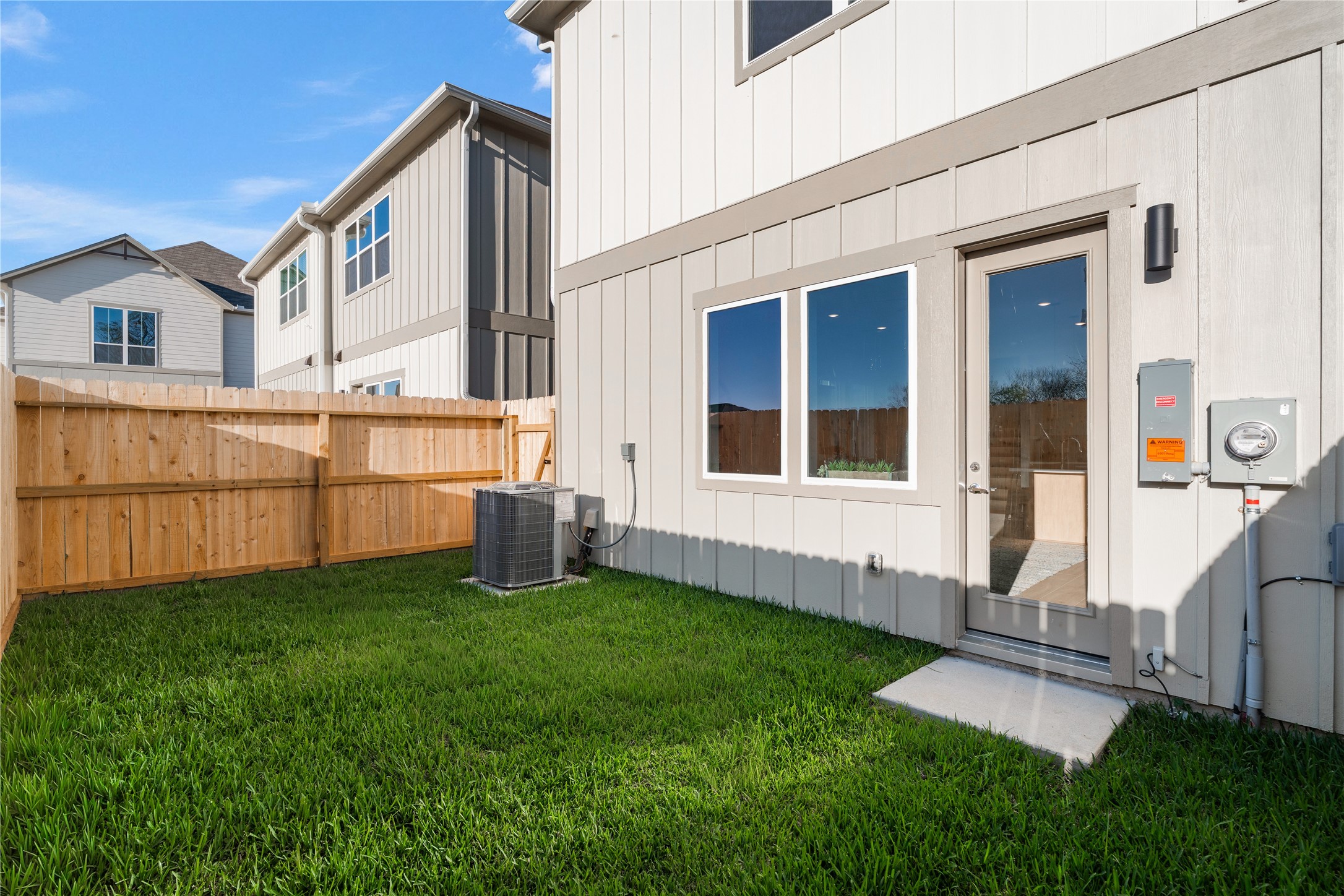 6505 Rena Street Houston, TX 77092 - Photo 26 of 28 Fully fenced backyard with a clean grass lot, privacy on both sides, and a direct step out from the living area — a blank slate ready to use.
