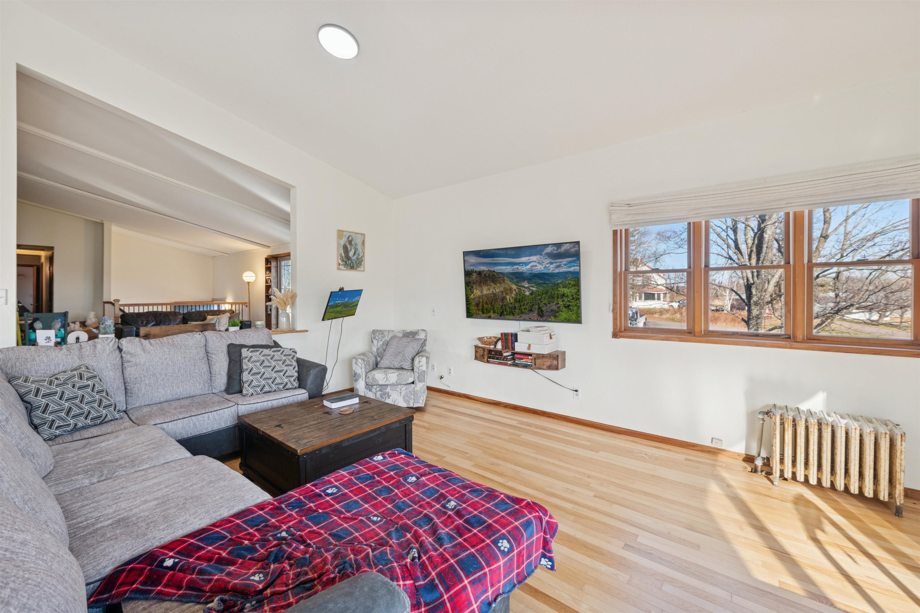 19805 Keystone Road Mason, WI 54856 - Photo 11 of 25 Living area featuring radiator, light wood-style flooring, and plenty of natural light