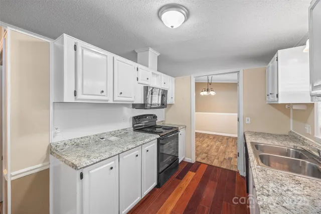 a kitchen with granite countertop kitchen island wooden cabinets granite counter tops and a stove