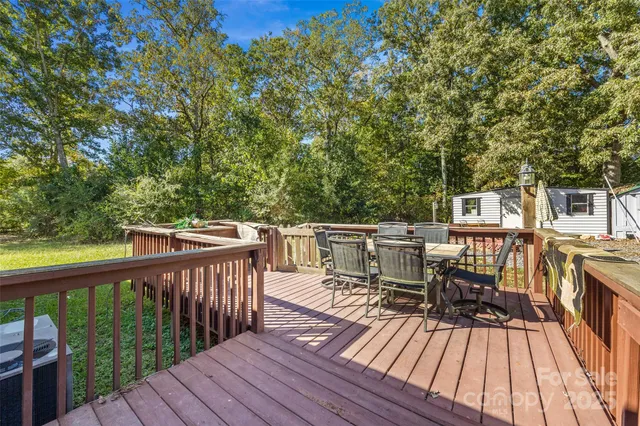 a view of house with wooden deck and furniture