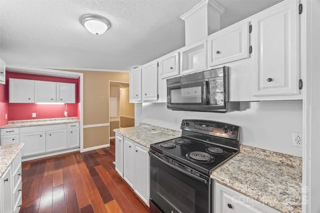 a kitchen with a stove a sink and a microwave