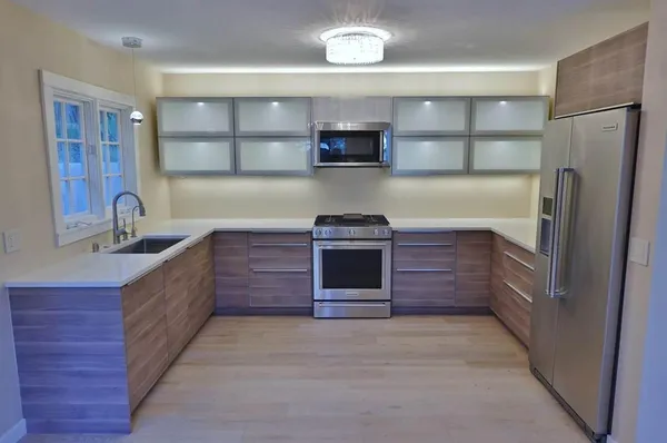 a kitchen with a stainless steel appliances wooden floor and a counter top space