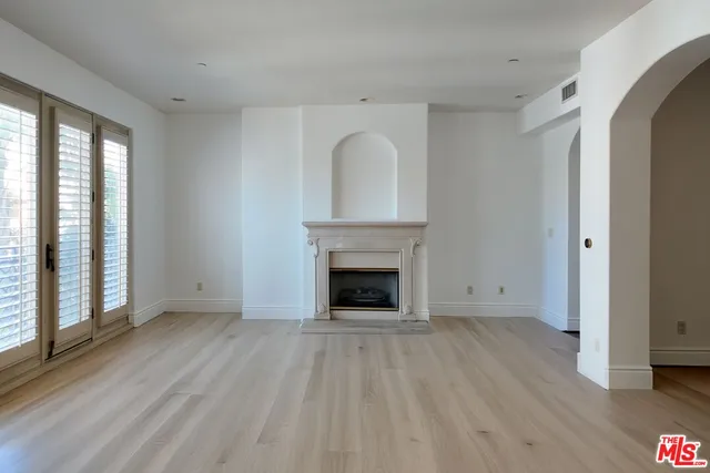 a view of a livingroom with wooden floor and a fireplace