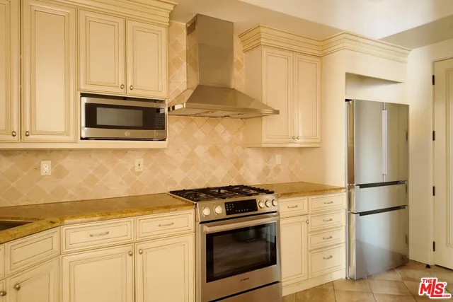 a kitchen with granite countertop white cabinets and stainless steel appliances