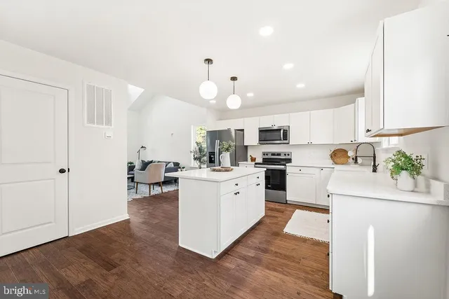 a kitchen with white cabinets and white appliances