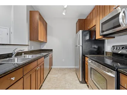 a kitchen with stainless steel appliances granite countertop a stove a sink and a refrigerator
