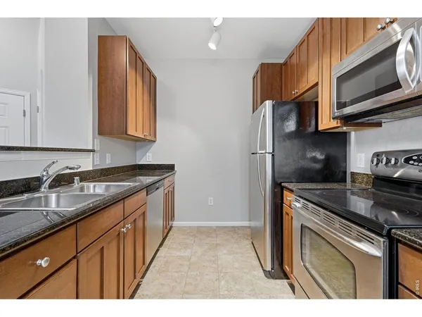 a kitchen with stainless steel appliances granite countertop a stove a sink and a refrigerator