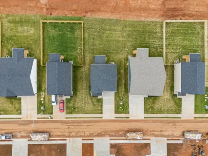 an aerial view of residential houses with outdoor space and river