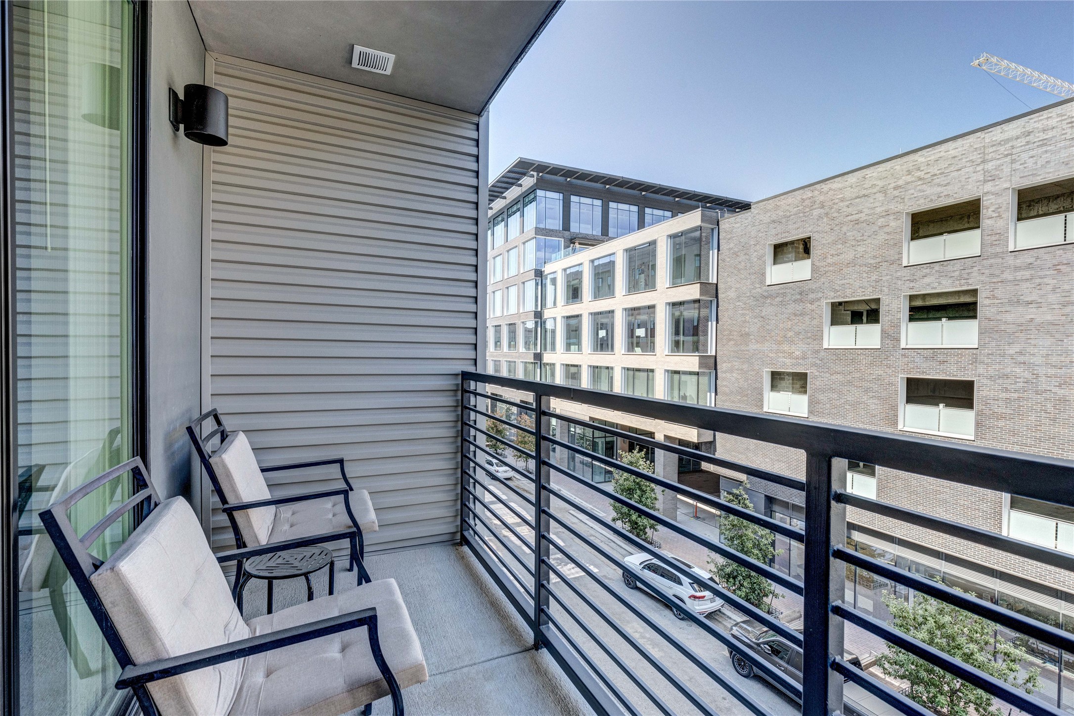 1701 Simond Avenue, Unit 301 Austin, TX 78723 - Photo 15 of 26 a view of a balcony with two chairs and a potted plant on a wooden floor