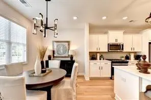 a kitchen with stainless steel appliances kitchen island granite countertop a sink a stove a dining table and chairs