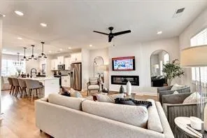 a living room with furniture and a view of kitchen