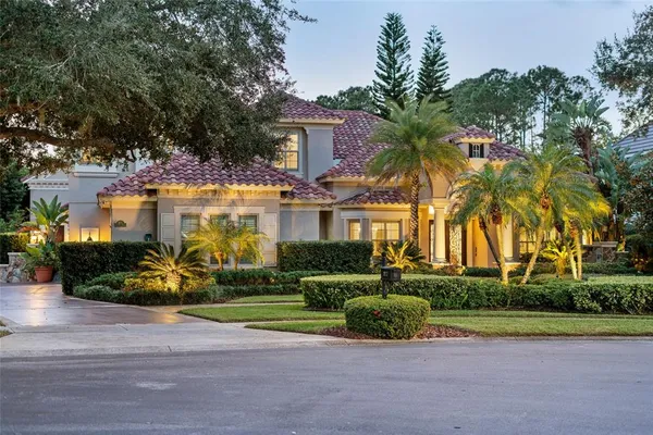 a front view of a house with a garden and trees