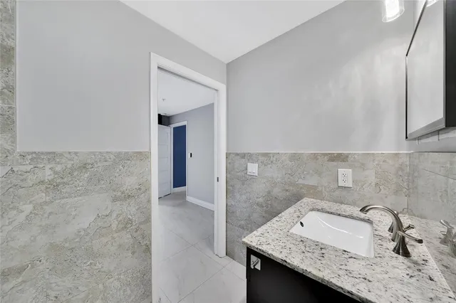 a view of an empty room with wooden floor and a ceiling fan