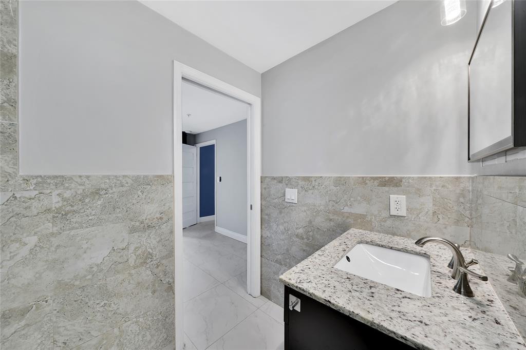 2725 Northeast 8th Avenue, Unit 113 Wilton Manors, FL 33334 - Photo 11 of 72 a bathroom with a sink and a mirror