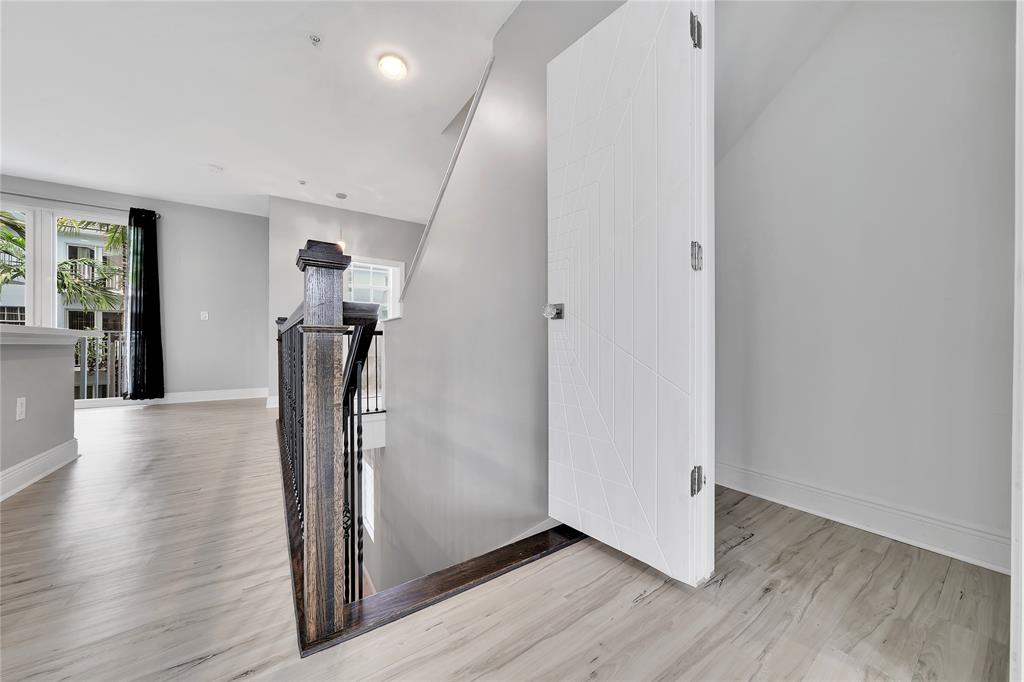 2725 Northeast 8th Avenue, Unit 113 Wilton Manors, FL 33334 - Photo 13 of 72 a view of a hallway with wooden floor and stairs