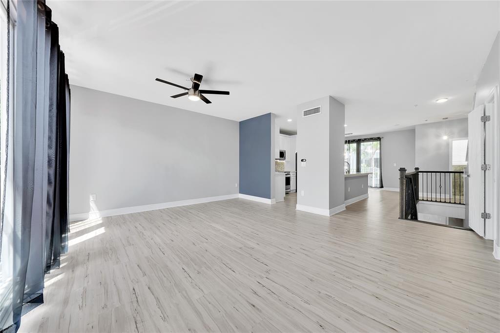 2725 Northeast 8th Avenue, Unit 113 Wilton Manors, FL 33334 - Photo 15 of 72 a view of an empty room with wooden floor and a ceiling fan