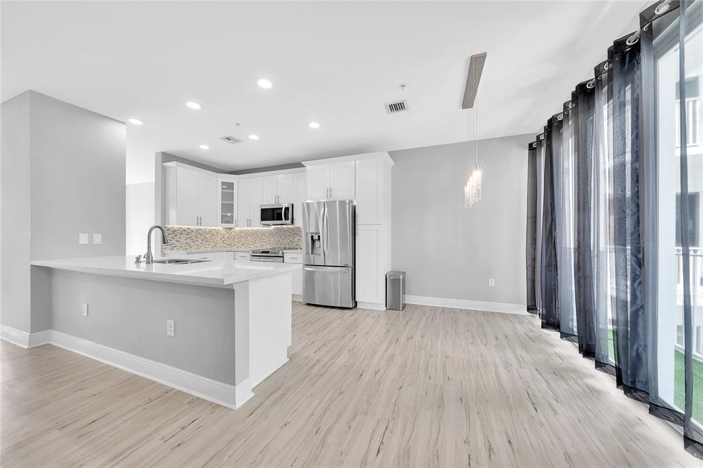 2725 Northeast 8th Avenue, Unit 113 Wilton Manors, FL 33334 - Photo 18 of 72 a kitchen with stainless steel appliances granite countertop a refrigerator and a sink