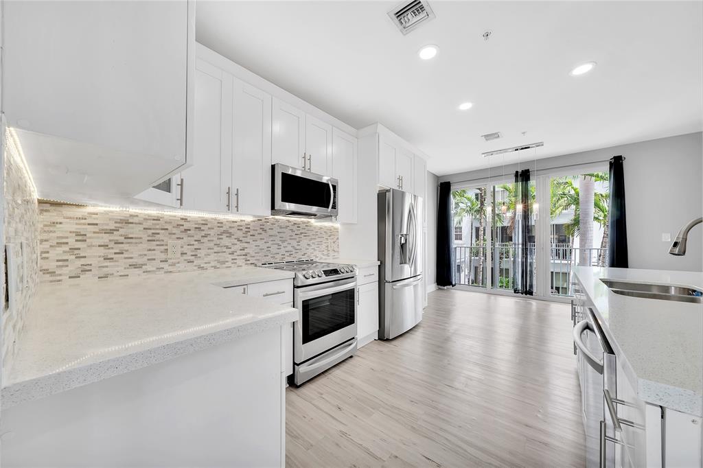 2725 Northeast 8th Avenue, Unit 113 Wilton Manors, FL 33334 - Photo 21 of 72 a large kitchen with stainless steel appliances granite countertop a stove and a sink