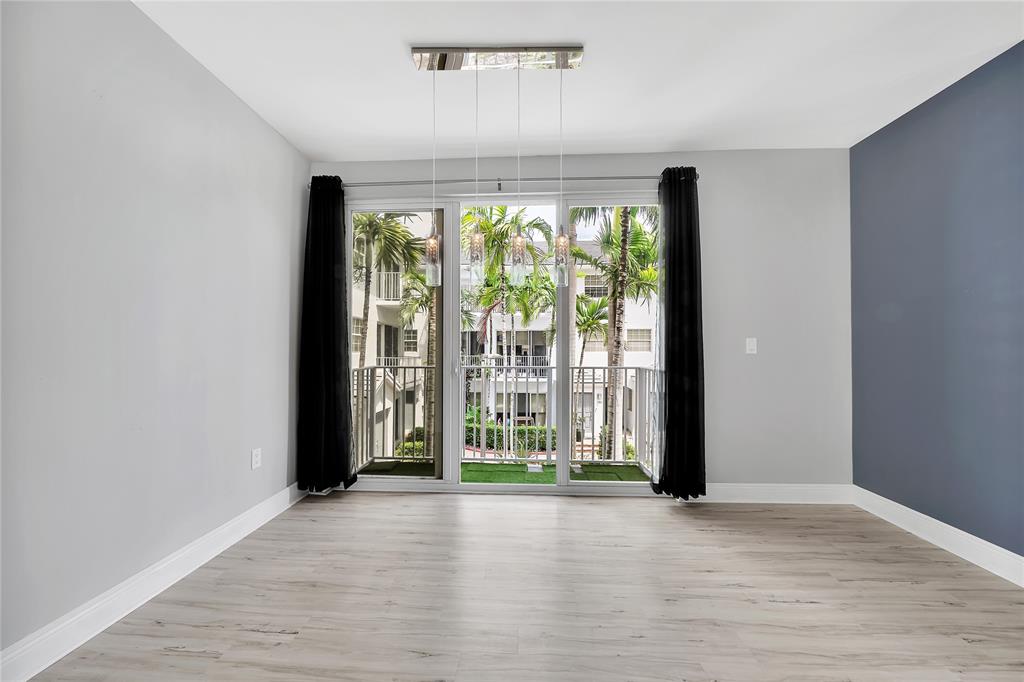 2725 Northeast 8th Avenue, Unit 113 Wilton Manors, FL 33334 - Photo 24 of 72 a view of an empty room with wooden floor and a window