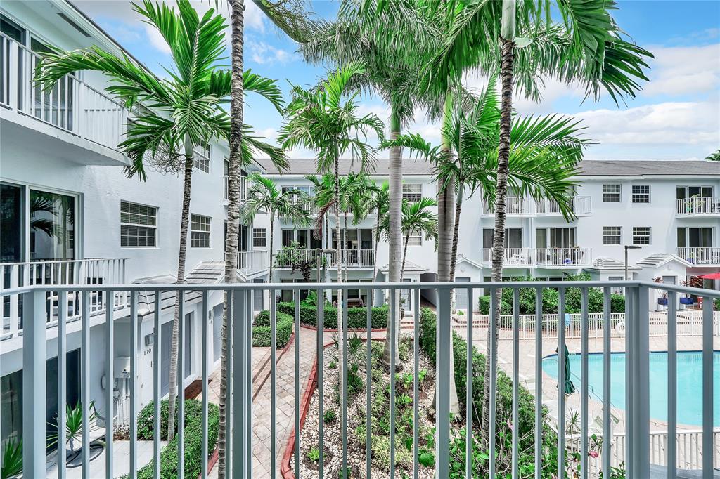 2725 Northeast 8th Avenue, Unit 113 Wilton Manors, FL 33334 - Photo 27 of 72 a view of a house with a large window and palm trees