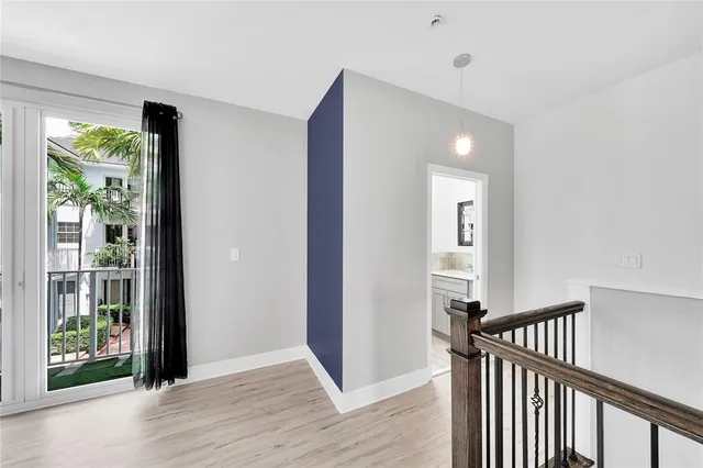 a view of a hallway with wooden floor and staircase