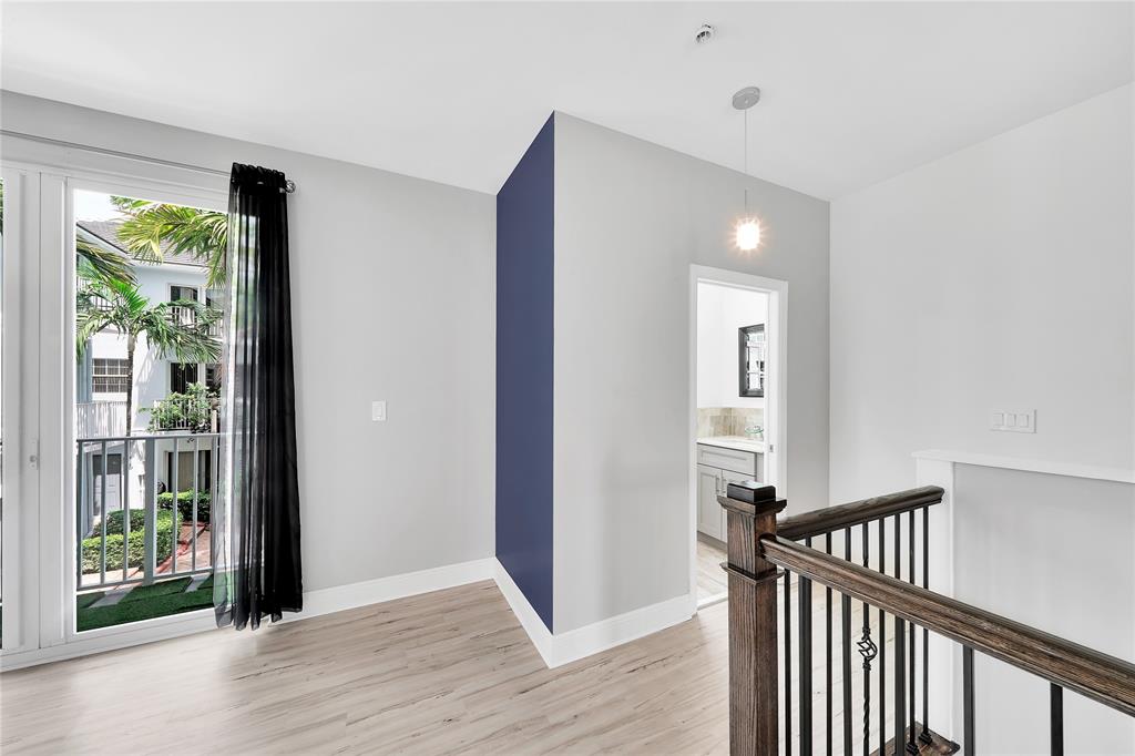 2725 Northeast 8th Avenue, Unit 113 Wilton Manors, FL 33334 - Photo 29 of 72 a view of a hallway with wooden floor and stairs