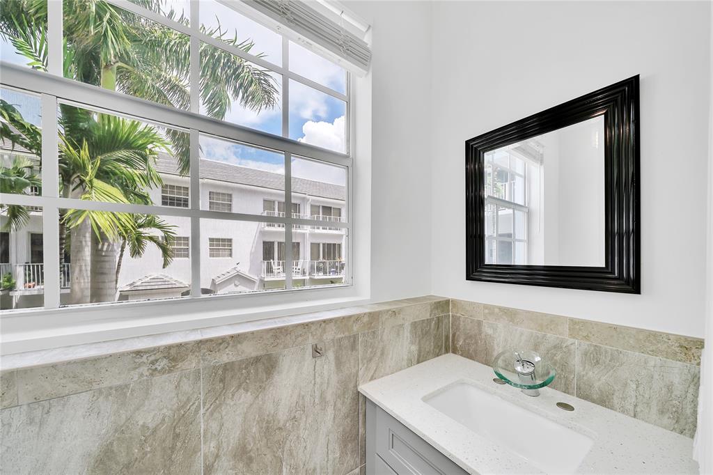 2725 Northeast 8th Avenue, Unit 113 Wilton Manors, FL 33334 - Photo 30 of 72 a bathroom with a sink and a mirror