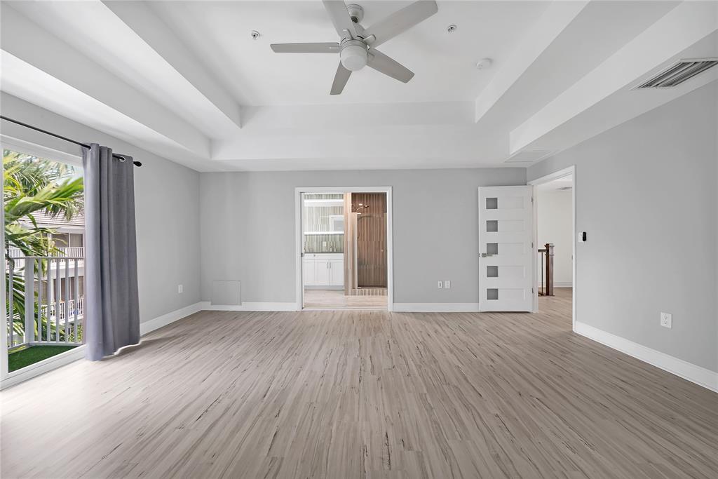 2725 Northeast 8th Avenue, Unit 113 Wilton Manors, FL 33334 - Photo 39 of 72 an empty room with wooden floor and windows