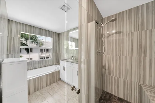a view of a hallway with wooden floor and a bathroom