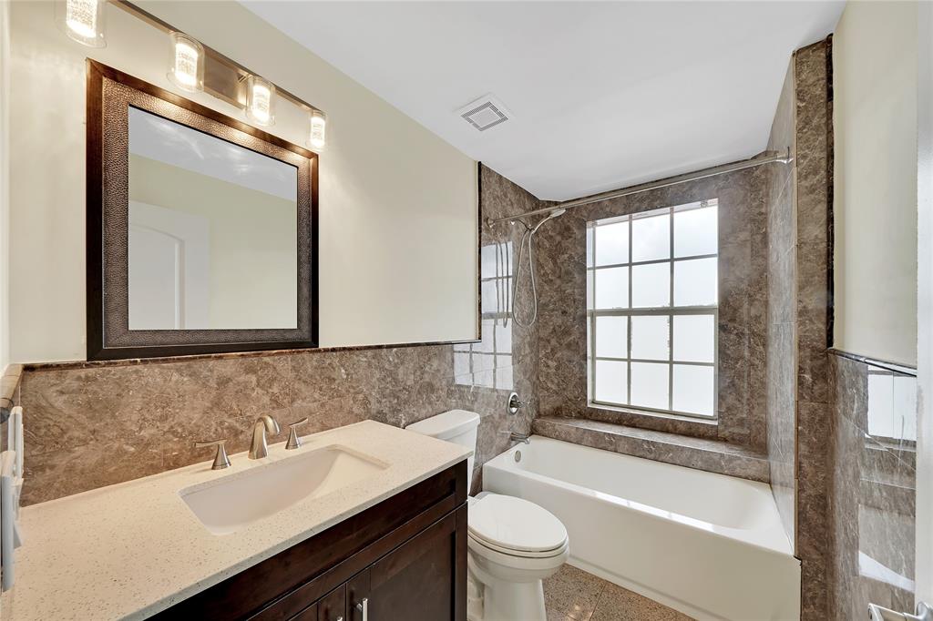 2725 Northeast 8th Avenue, Unit 113 Wilton Manors, FL 33334 - Photo 53 of 72 a bathroom with a bathtub shower sink vanity mirror and toilet