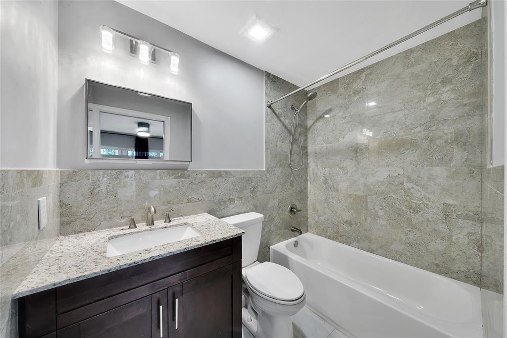 2725 Northeast 8th Avenue, Unit 113 Wilton Manors, FL 33334 - Photo 10 of 72 a bathroom with a granite countertop sink toilet and shower